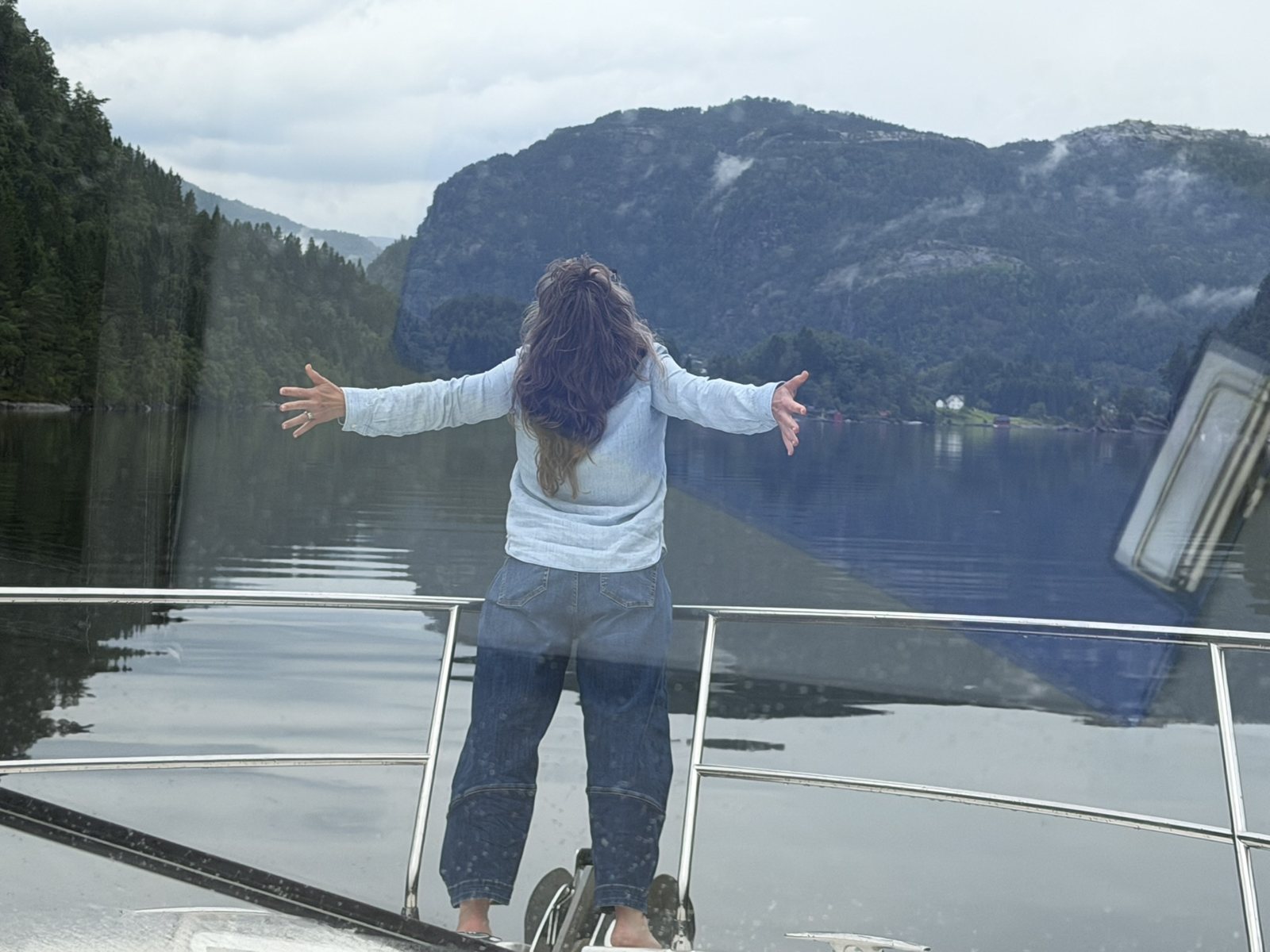 Arms out at the bow as the fjord opens up