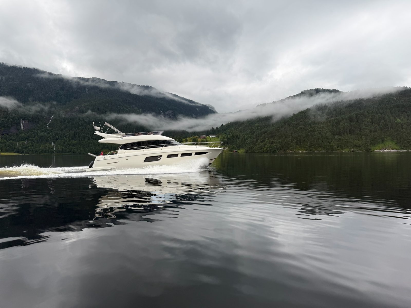 Fjord Queen under way on still water, mist on the hillsides