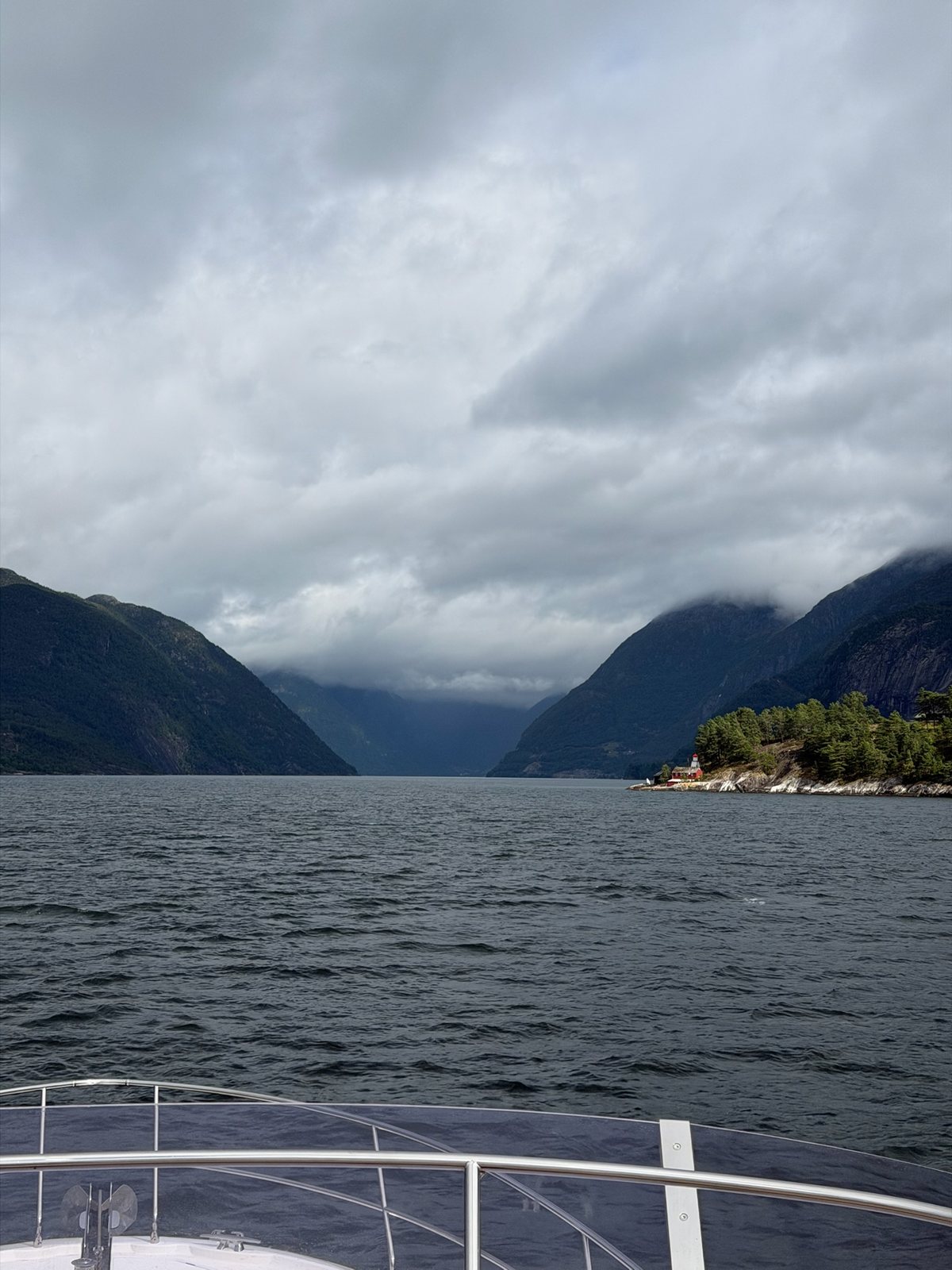 Into the narrowing fjord, clouds settling on the walls
